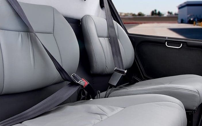 The gray leather seats inside a Robinson R22 helicopter.