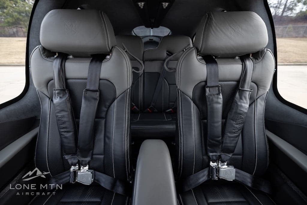 Front seats of a Cirrus SR22T with black leather and gray headrests.