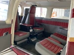 Interior view of the aircraft cabin with red and gray seats.