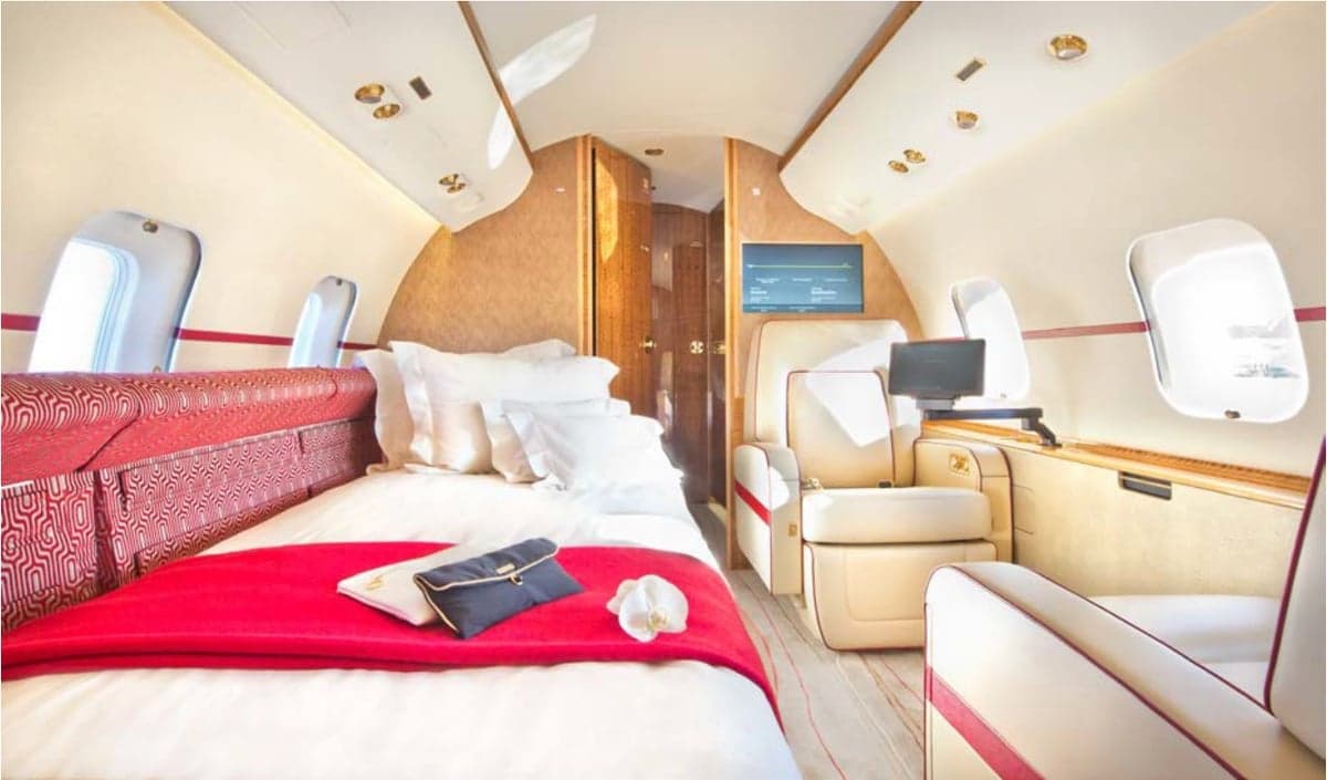 View of the aircraft's interior with a bed and a comfortable chair.