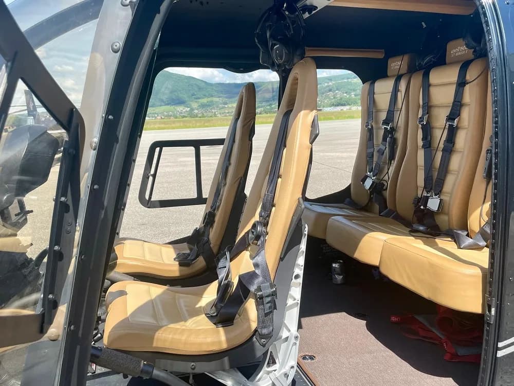 Interior view of the helicopter cabin with tan leather seats.