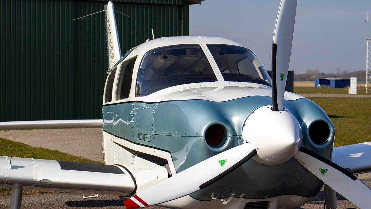 Close up of the front of a blue and white Archer DX aircraft.