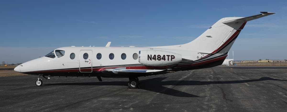 A Hawker 400XP aircraft with registration N484TP is parked on the tarmac.