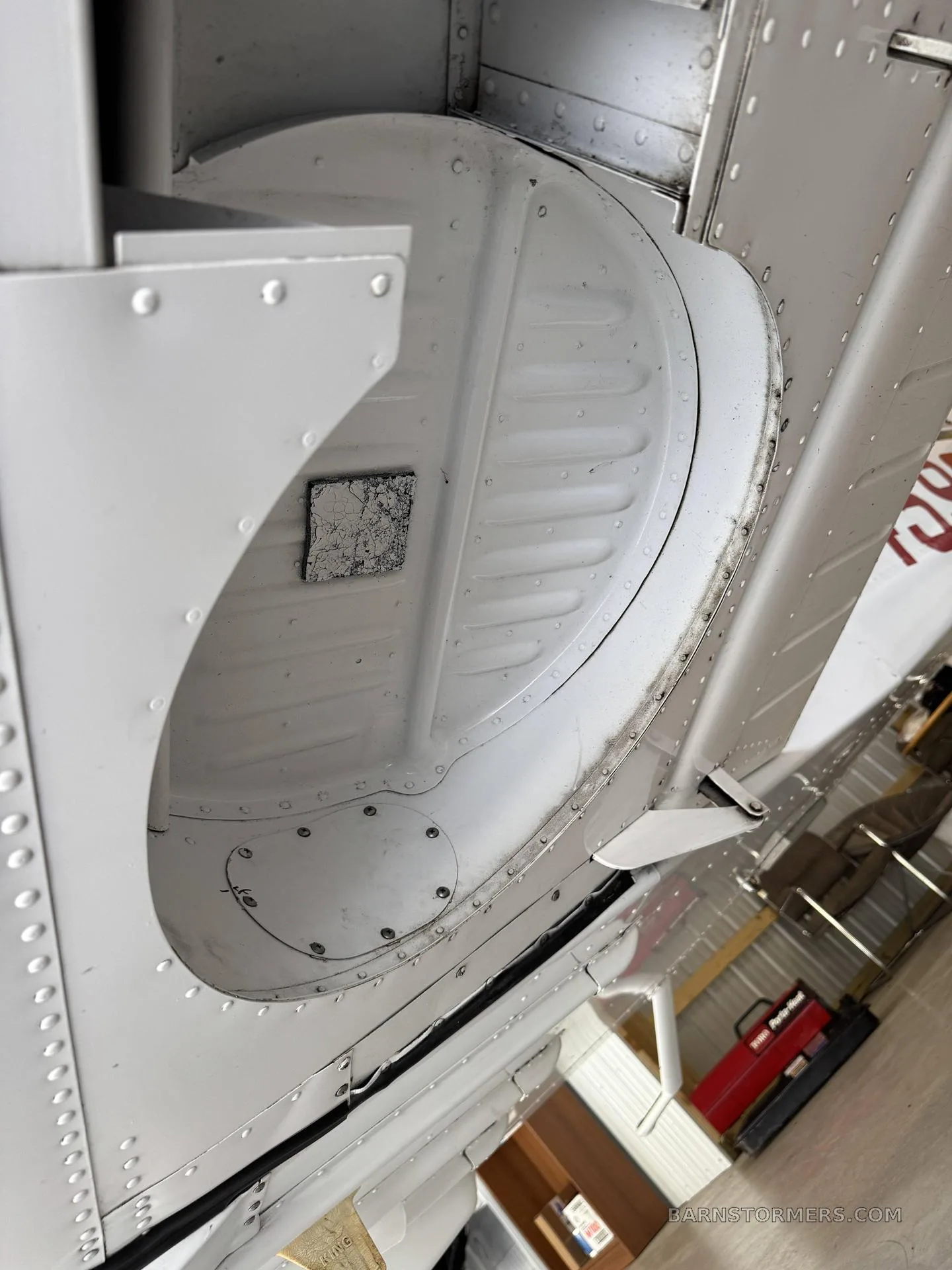 A close-up view of the internal structure of an aircraft, possibly a landing gear well, showing rivets and metal panels.