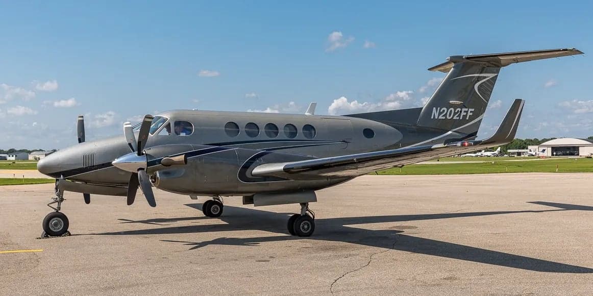 Side view of a gray King Air aircraft on the tarmac.