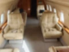 A blurry side view of the Challenger aircraft parked on the tarmac.