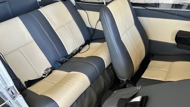 View of the aircraft's interior featuring gray and cream-colored seats.