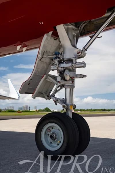 Close-up view of the main landing gear of the Dassault Falcon 900LX, showing its wheels and struts.