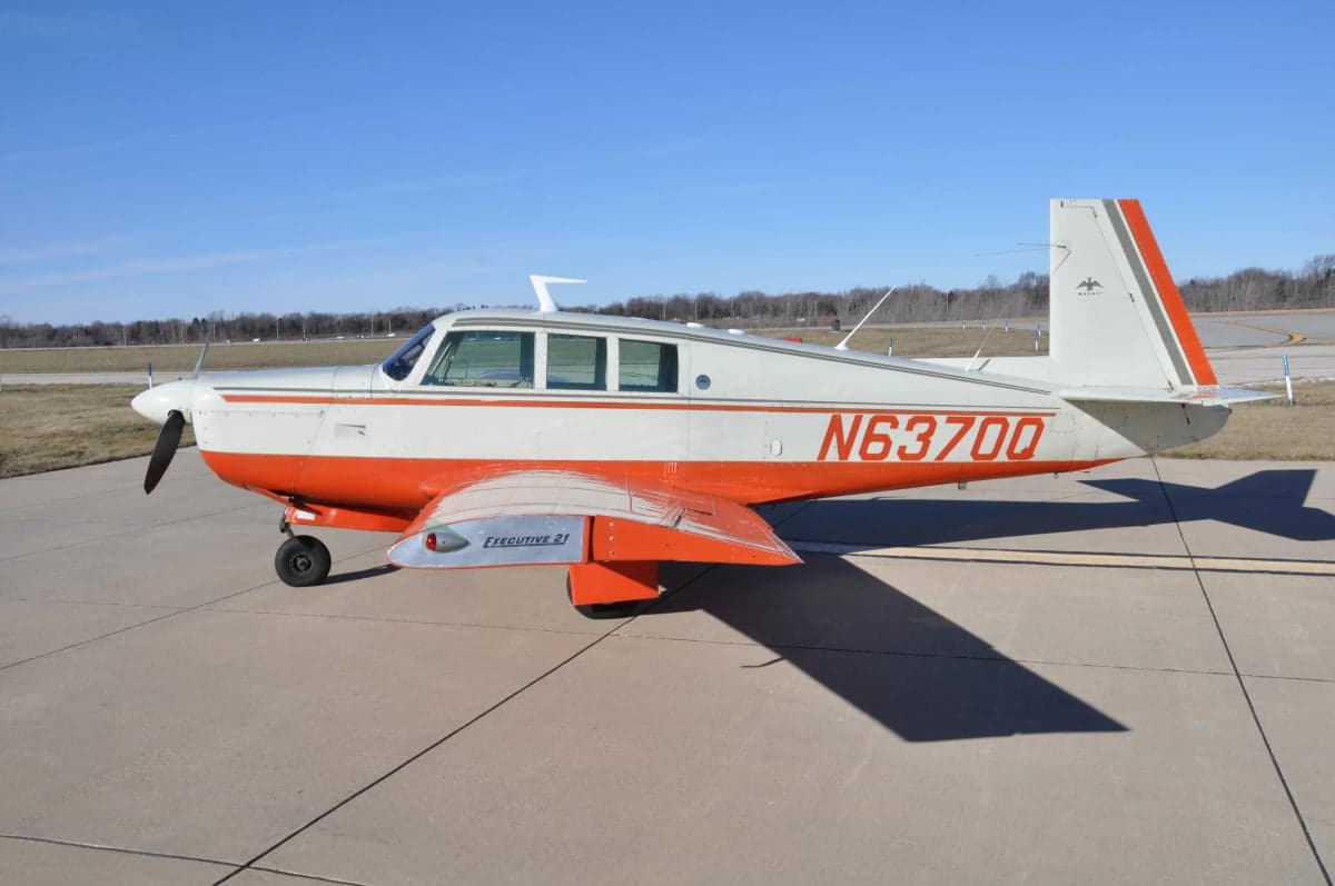 Side view of a Mooney M20F Executive 21 aircraft on the ground.