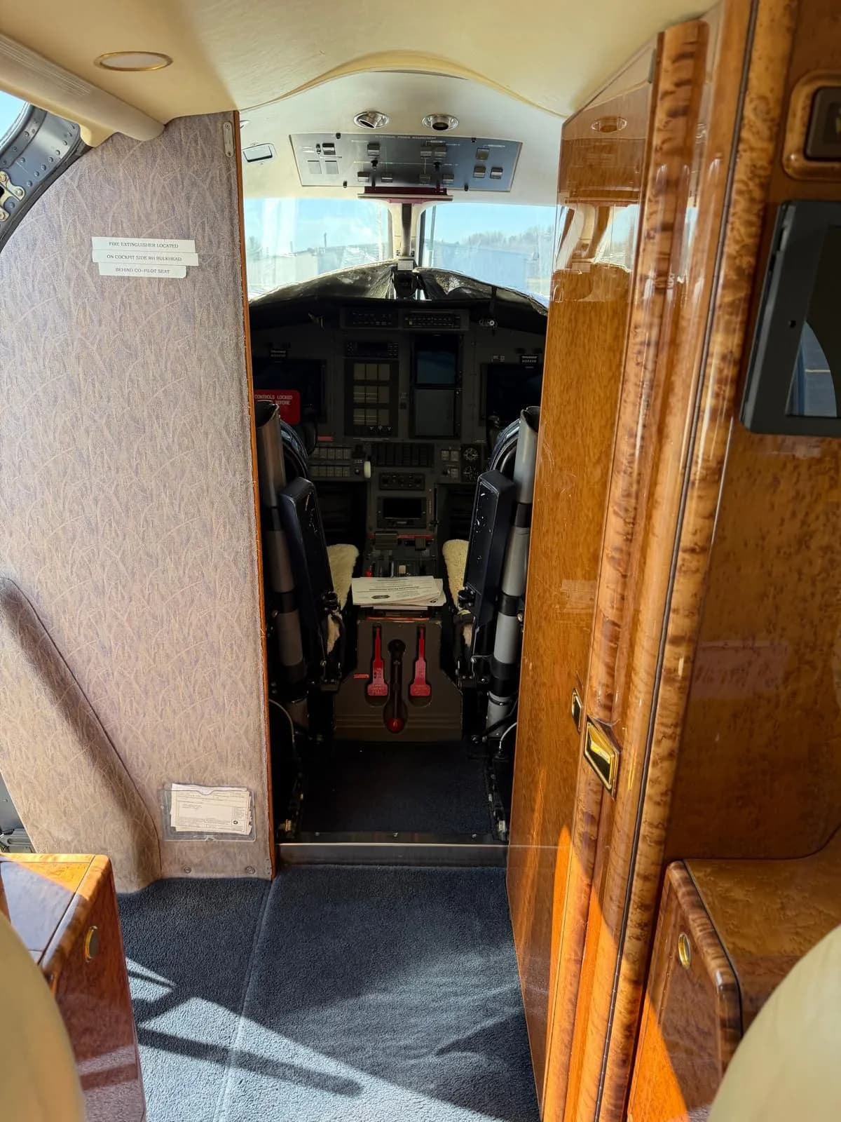 A view from the aircraft cabin looking into the cockpit, showing the instrument panel and pilot seats.