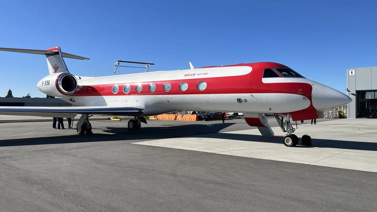 A side view of a red and white Gulfstream G650 business jet parked on an airfield, showing its registration B-3196.