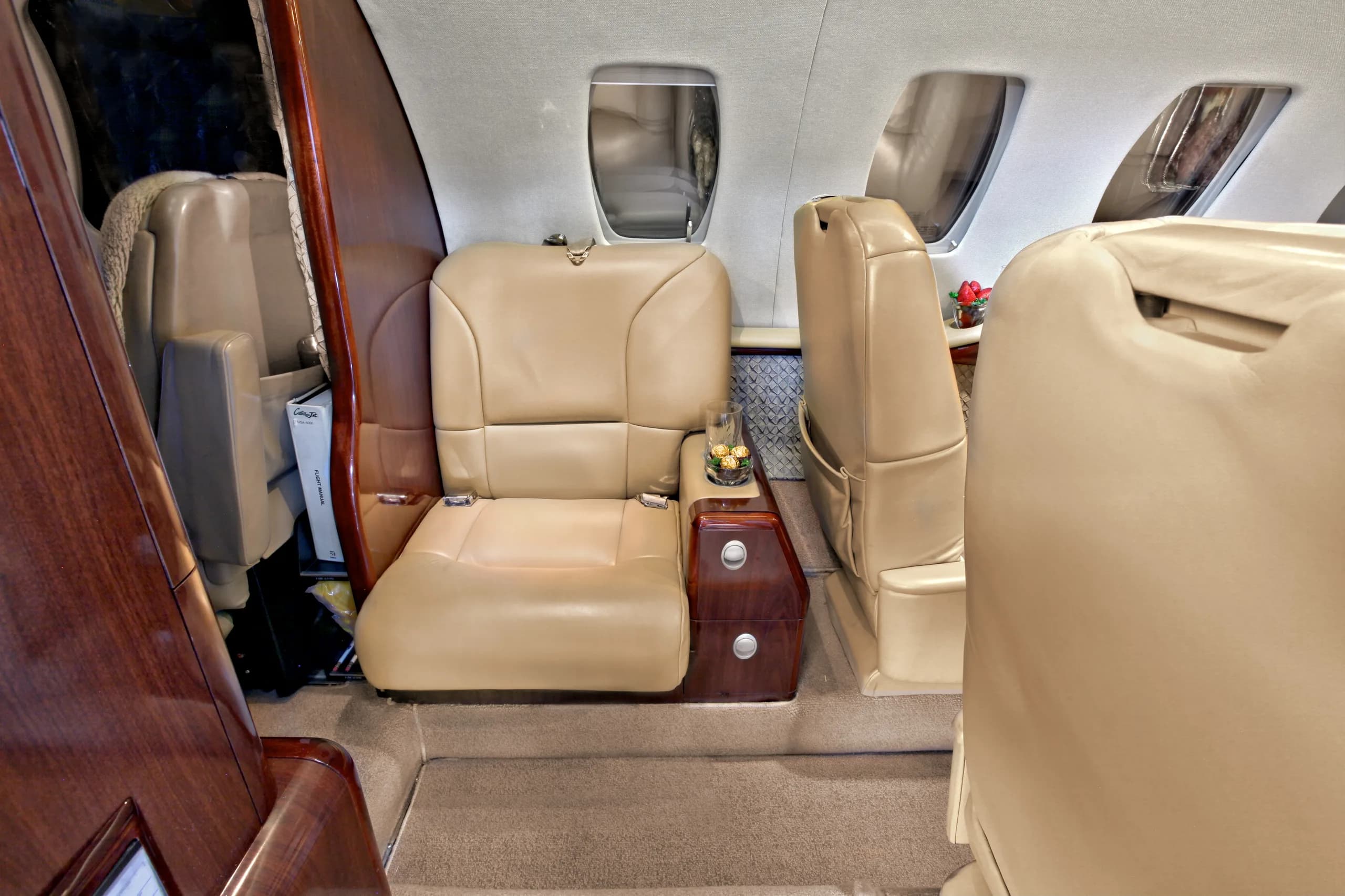 A view of the aircraft's interior, showing leather seats and wood trim.