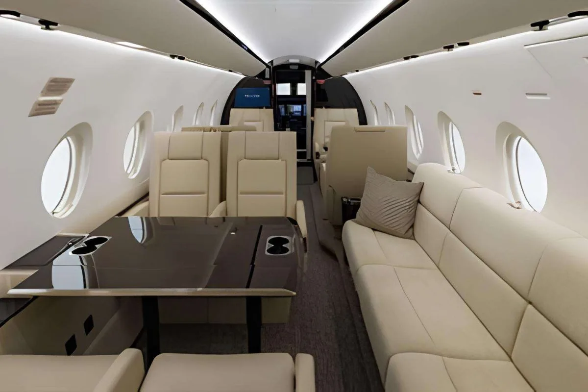 A view of the aircraft cabin with leather seats and a table.
