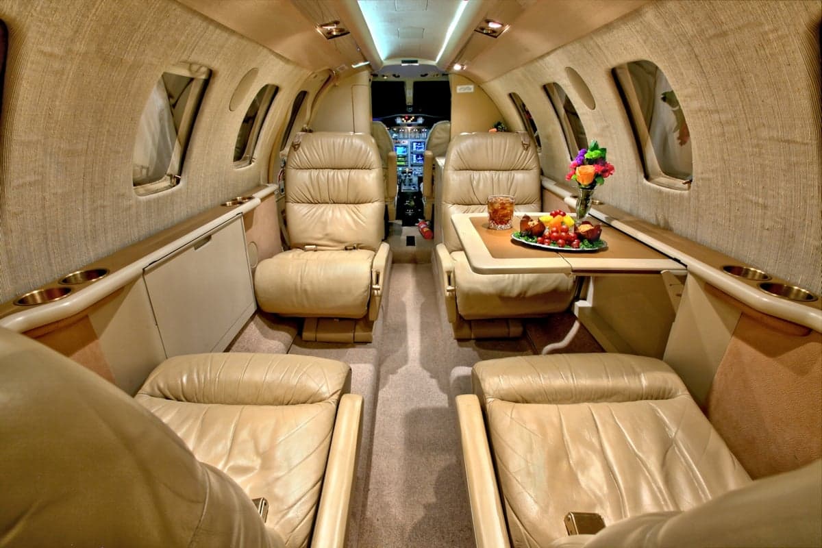 The interior of the CitationJet features leather seats and a table.