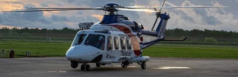 A white and blue Bristol helicopter with 'RESCUE' markings on the tarmac.