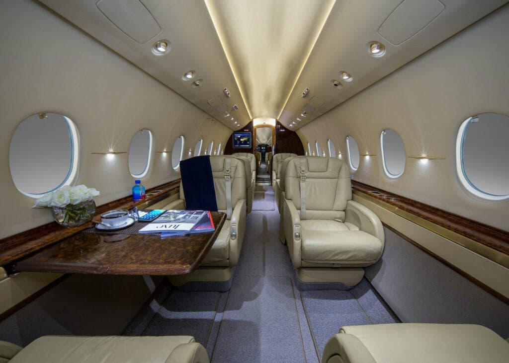 View of the galley and cockpit from inside the cabin of a private jet.