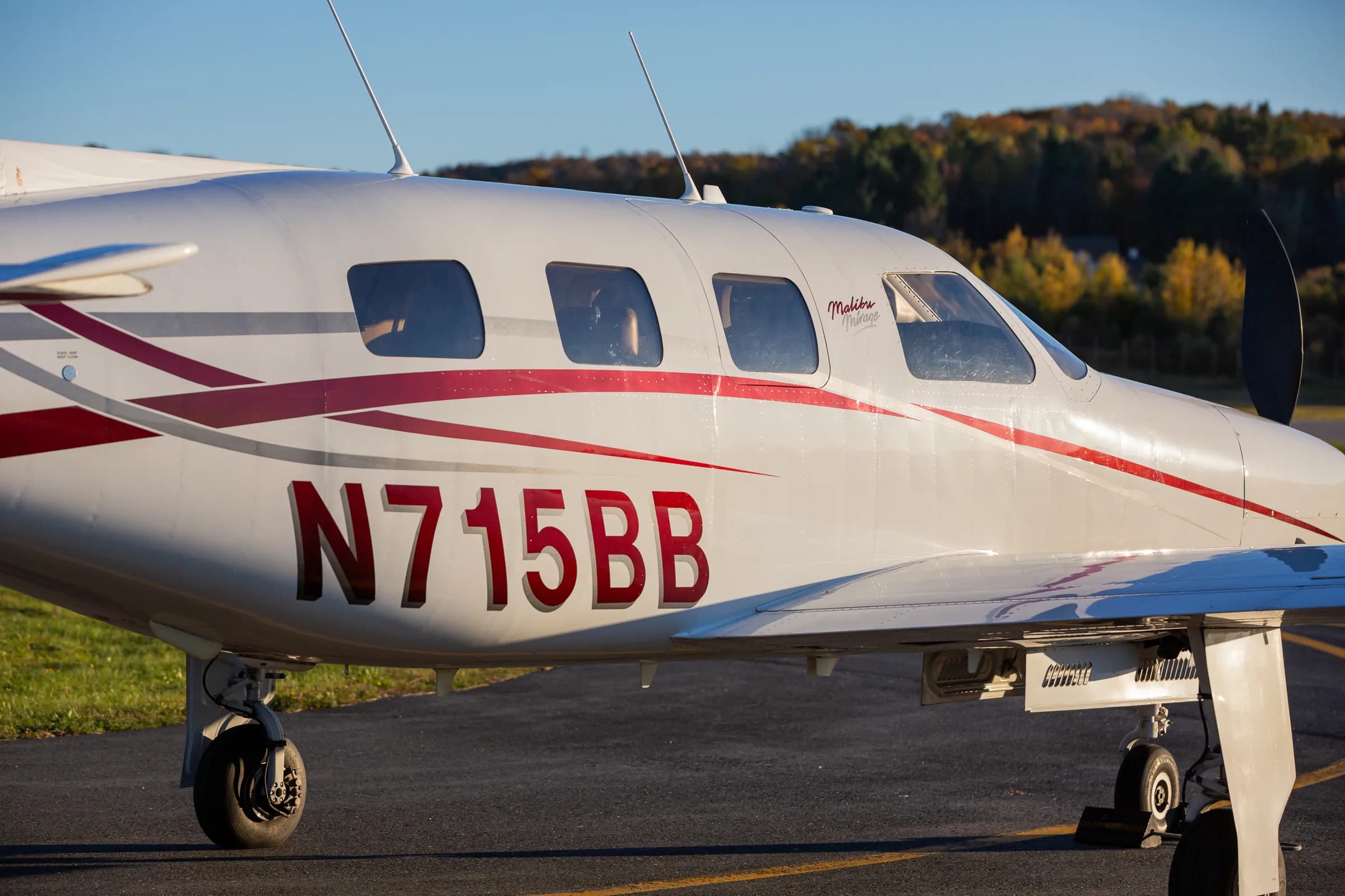 A close-up of the fuselage of Piper Malibu Mirage N715BB showing the cockpit and passenger windows.