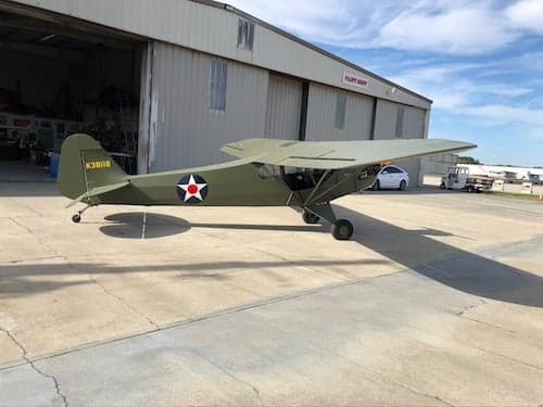 Side view of an olive drab aircraft with star insignia.