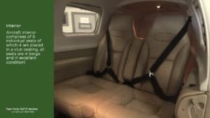 The beige leather interior of a Piper PA-46-500TP Meridian aircraft with club seating.