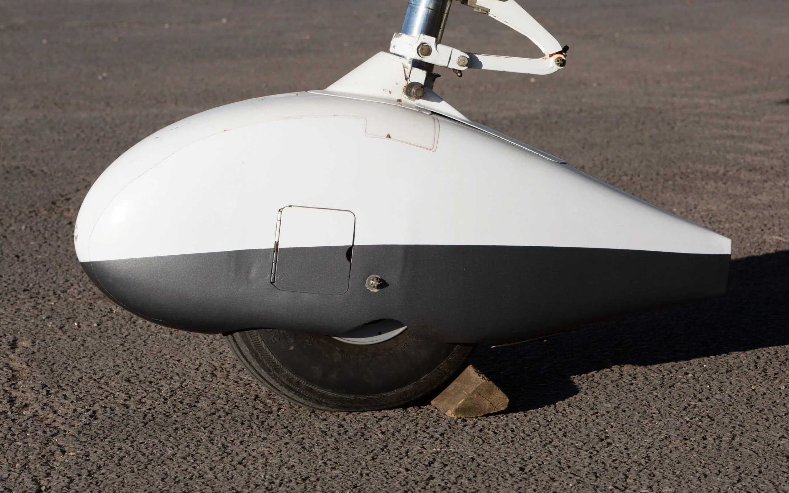 Close-up of the white and black main landing gear fairing of a Cessna 182T.