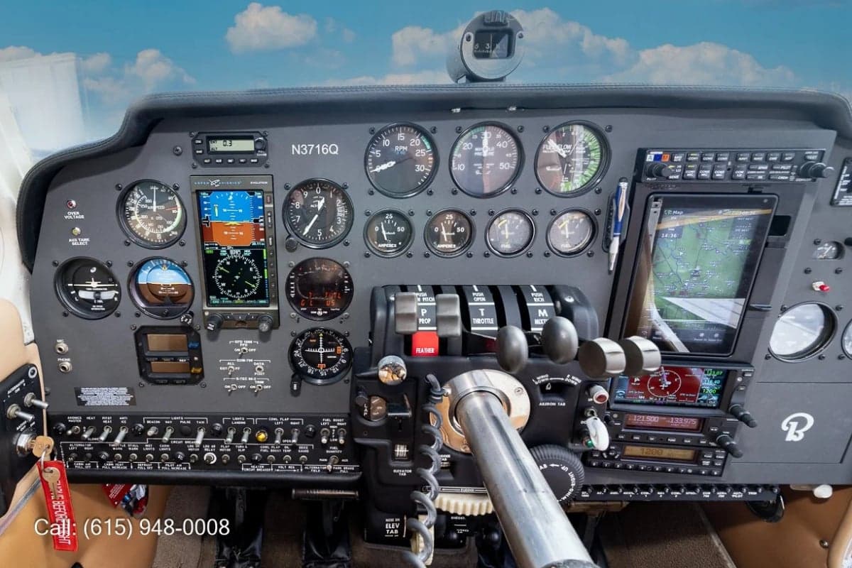 A close-up view of the aircraft's instrument panel, showing various gauges, switches, and a large digital display with a map.