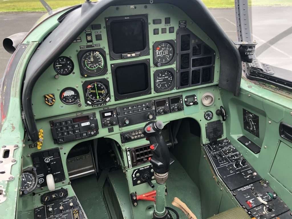 The cockpit of an aircraft with a green instrument panel.