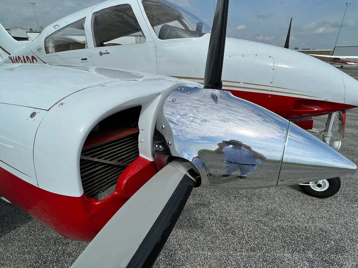 A close-up of the N1242G's polished propeller spinner and engine, reflecting the photographer.