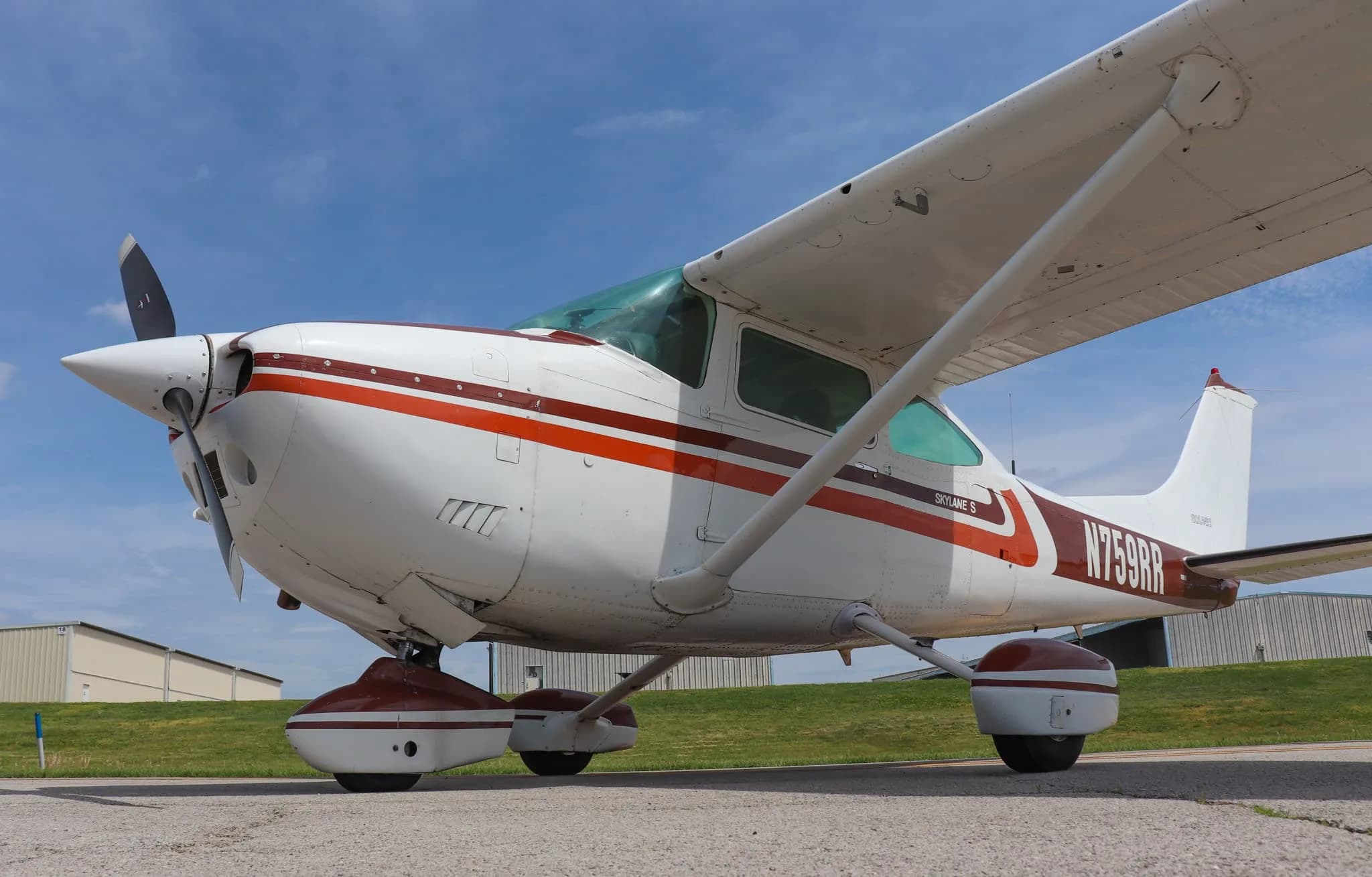 A low-angle front-quarter view of the Cessna Skylane S (N759RR) showing its landing gear and propeller.