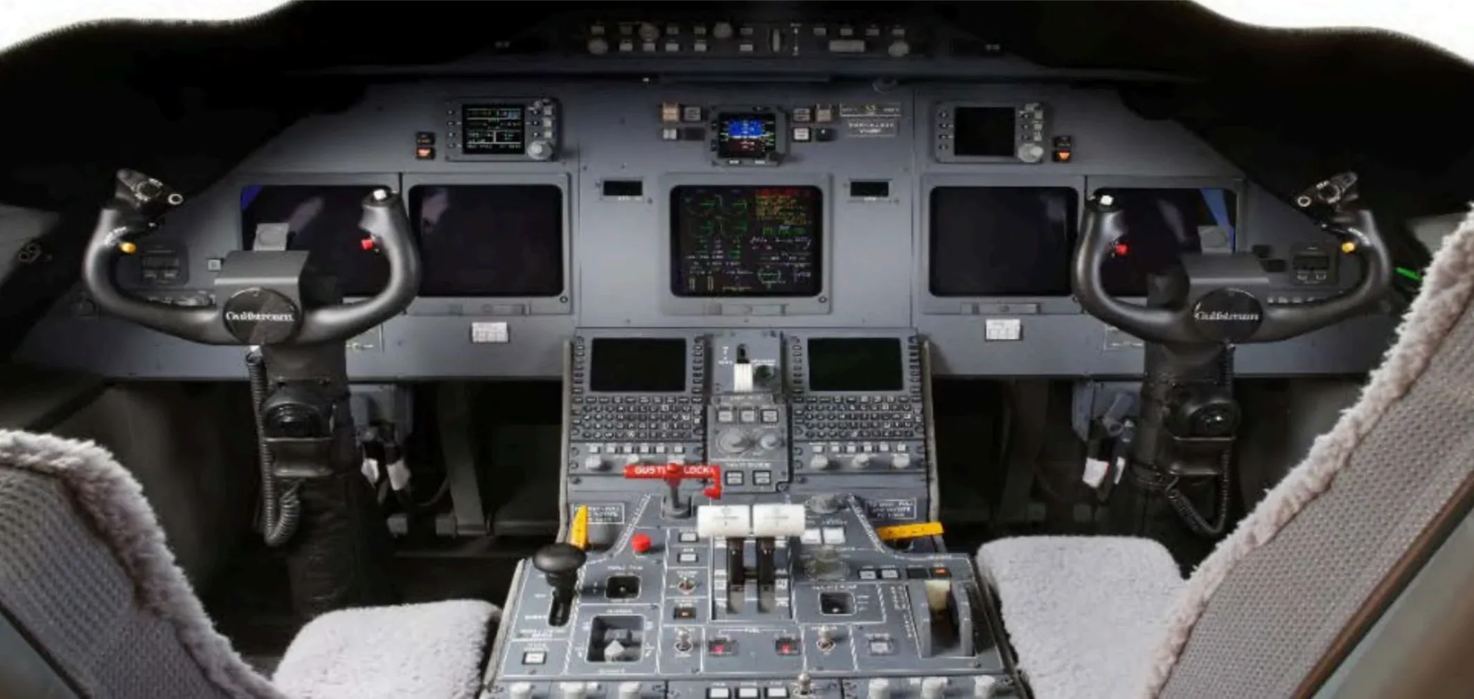 The cockpit of an aircraft showing the instrument panel, yokes, and central control console.