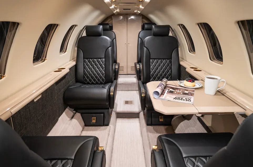 View of the interior cabin of the Cessna Citation Ultra, showing the seating arrangement and table.