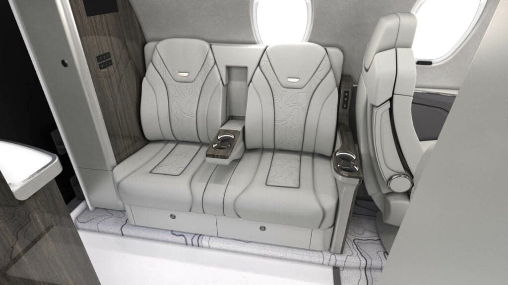 View of the aircraft's interior with white leather seats and wood trim.