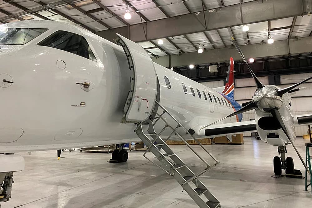 Close-up of an aircraft with an open door and stairs.