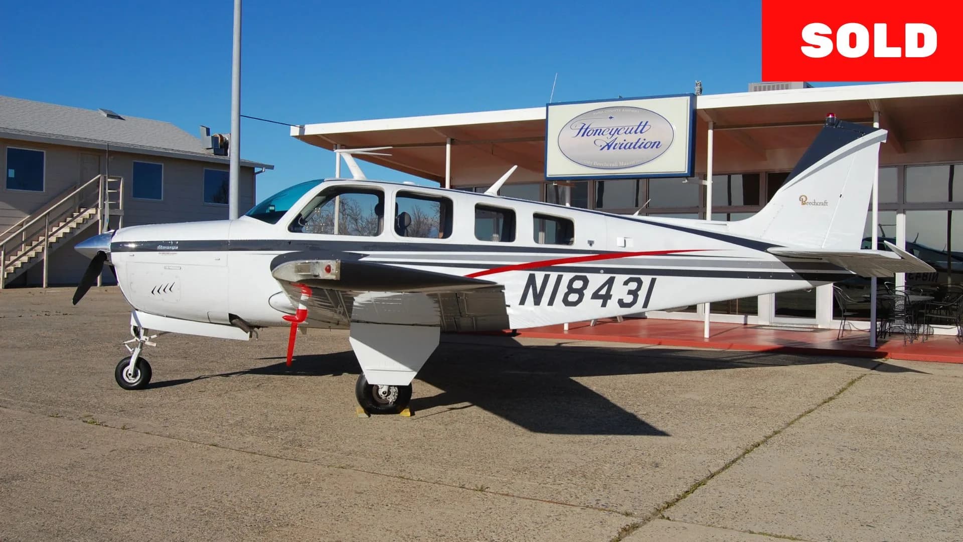 Beechcraft Bonanza with white and gray paint scheme, parked on the tarmac with "SOLD" overlay.