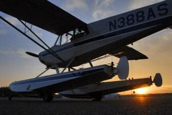 Seaplane parked on the ground at sunset.