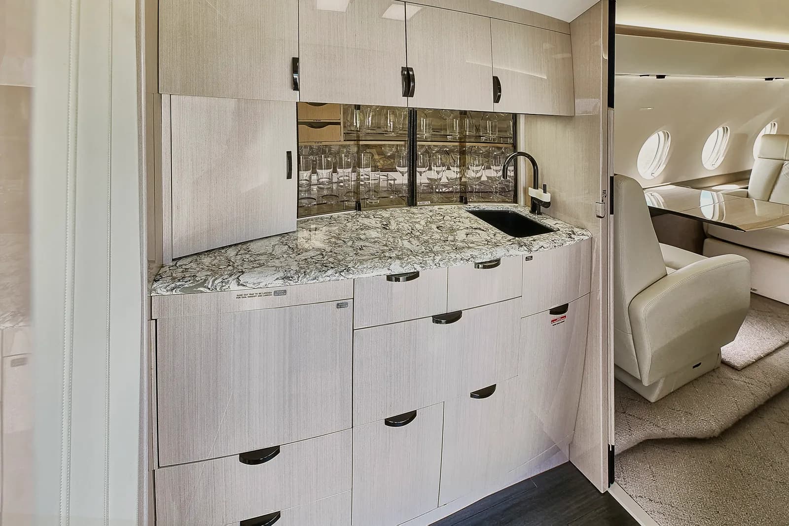 Aircraft galley with marble countertop and sink.