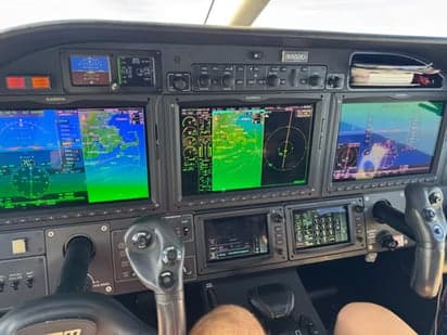 The cockpit of a TBM 930 aircraft with multiple display screens.