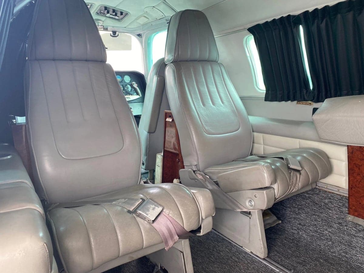 The interior of the aircraft features gray seats and black curtains.