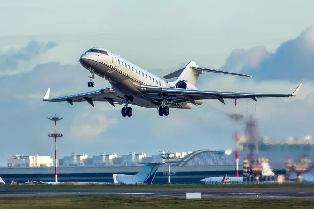 A Bombardier Challenger jet takes off from the runway.