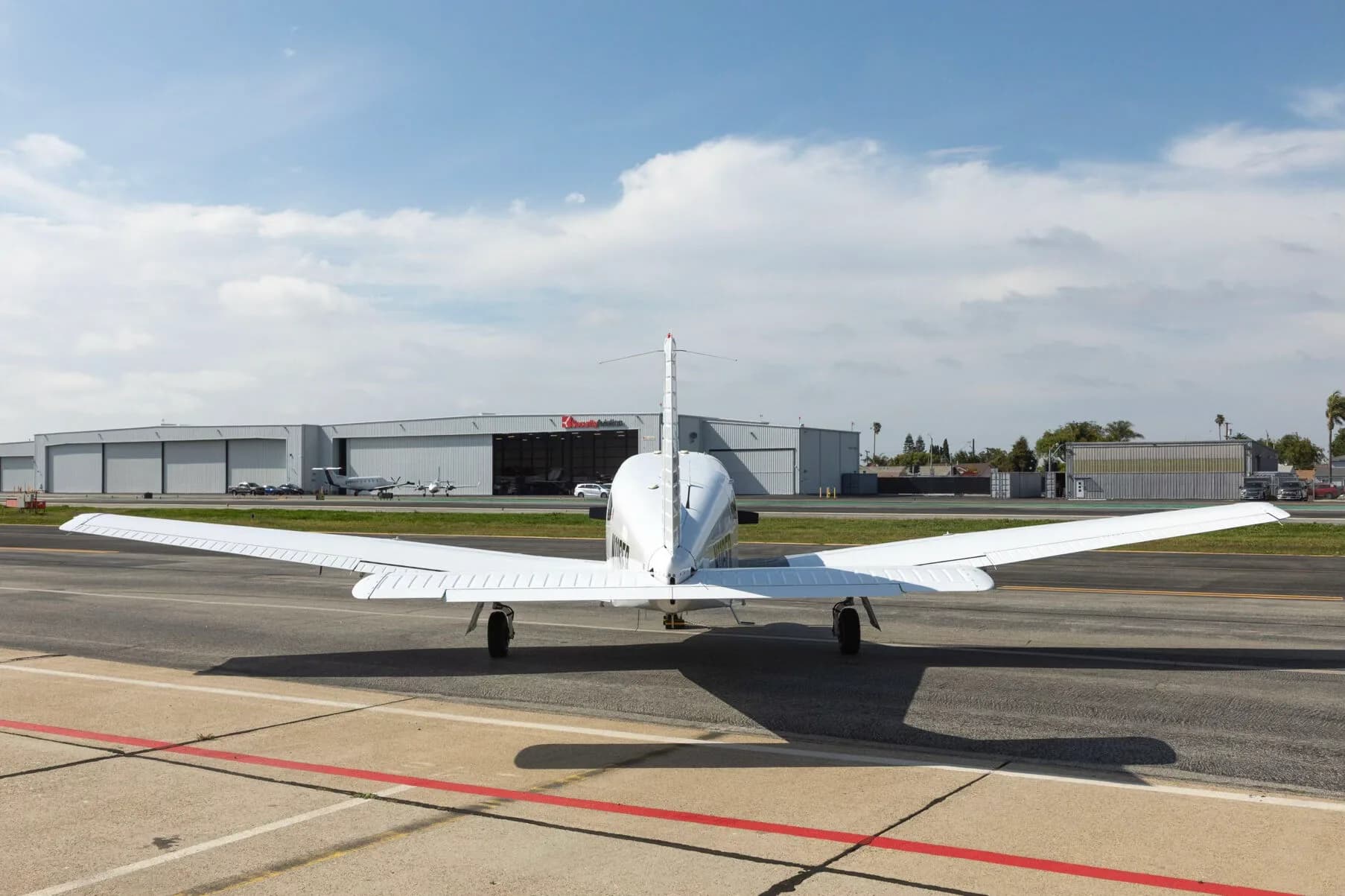 A rear view of a white Piper PA-28-181 Archer III aircraft parked on an airfield.