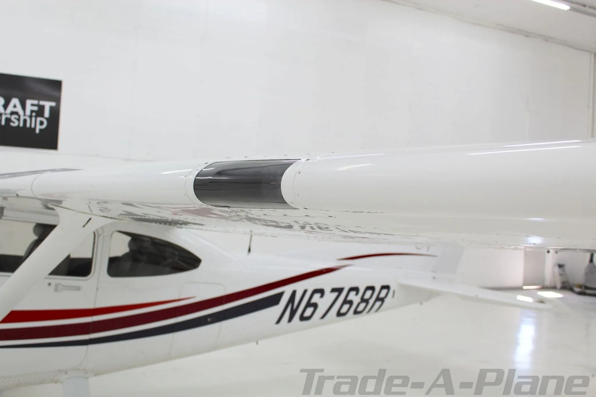 A close-up view of the wing and fuselage of the Cessna Skylane N6768R, showing the registration.
