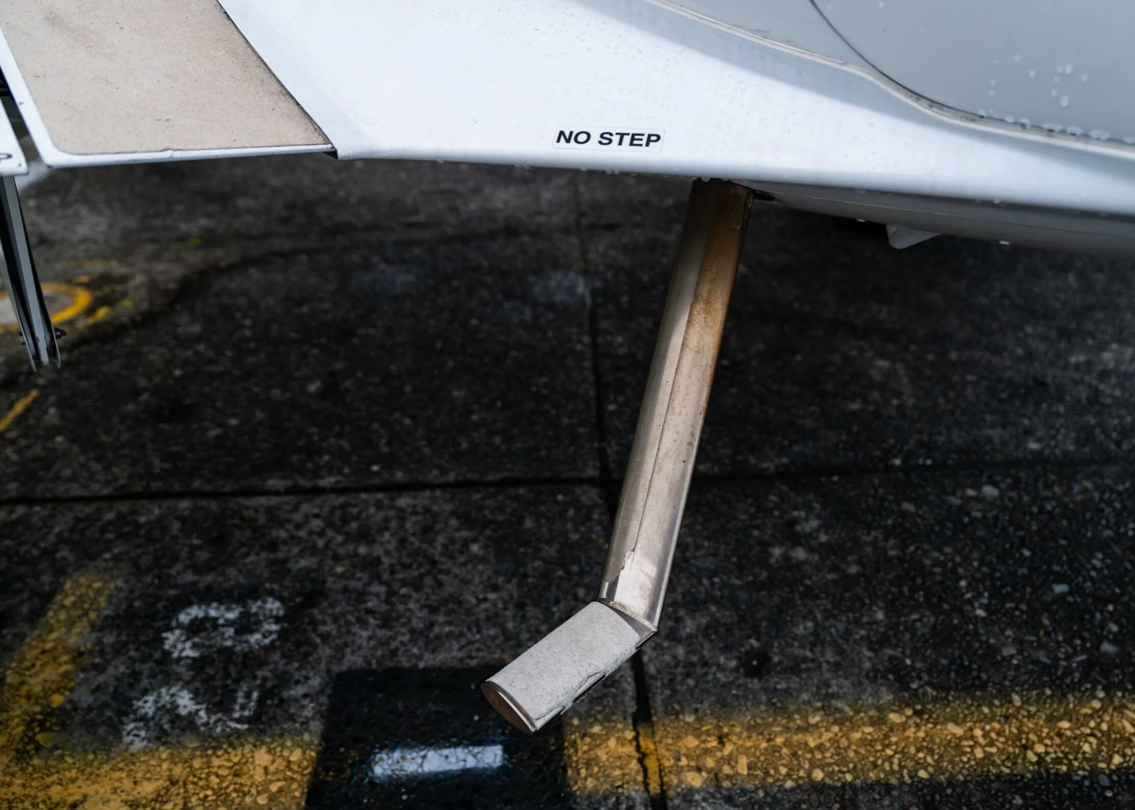 A close-up view of the exhaust pipe and "NO STEP" marking on the underside of the aircraft.