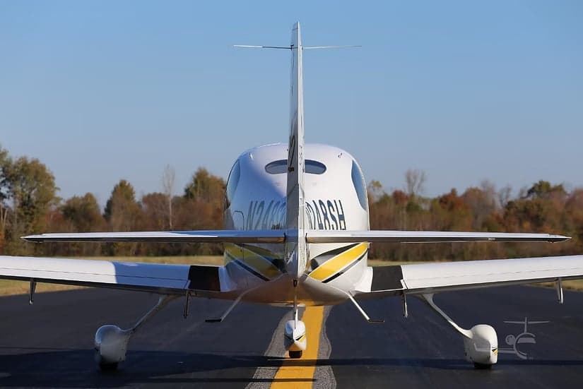 Rear view of a Cirrus SR22 aircraft with its tail and registration number visible.