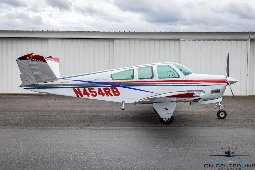 Side view of the Beechcraft Bonanza N454RB with a white and red paint scheme.