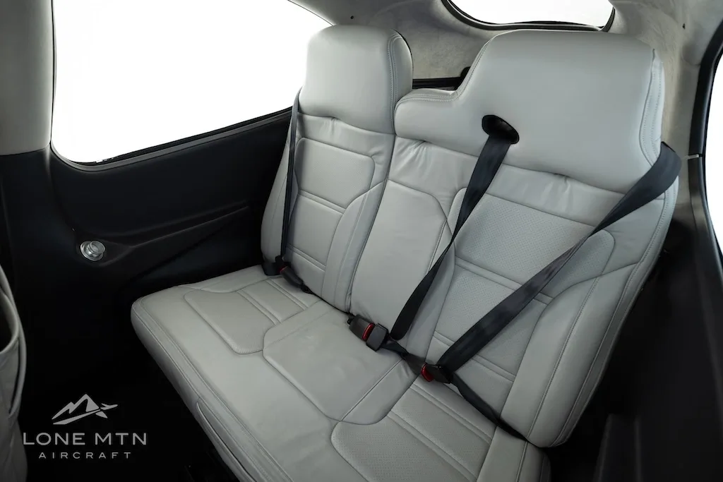 The light gray leather rear passenger seats of the Cirrus SR20 aircraft cabin.
