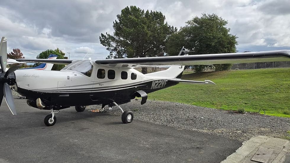 A black and white Cessna 208B Grand Caravan, registration N22VF, is parked on the tarmac.