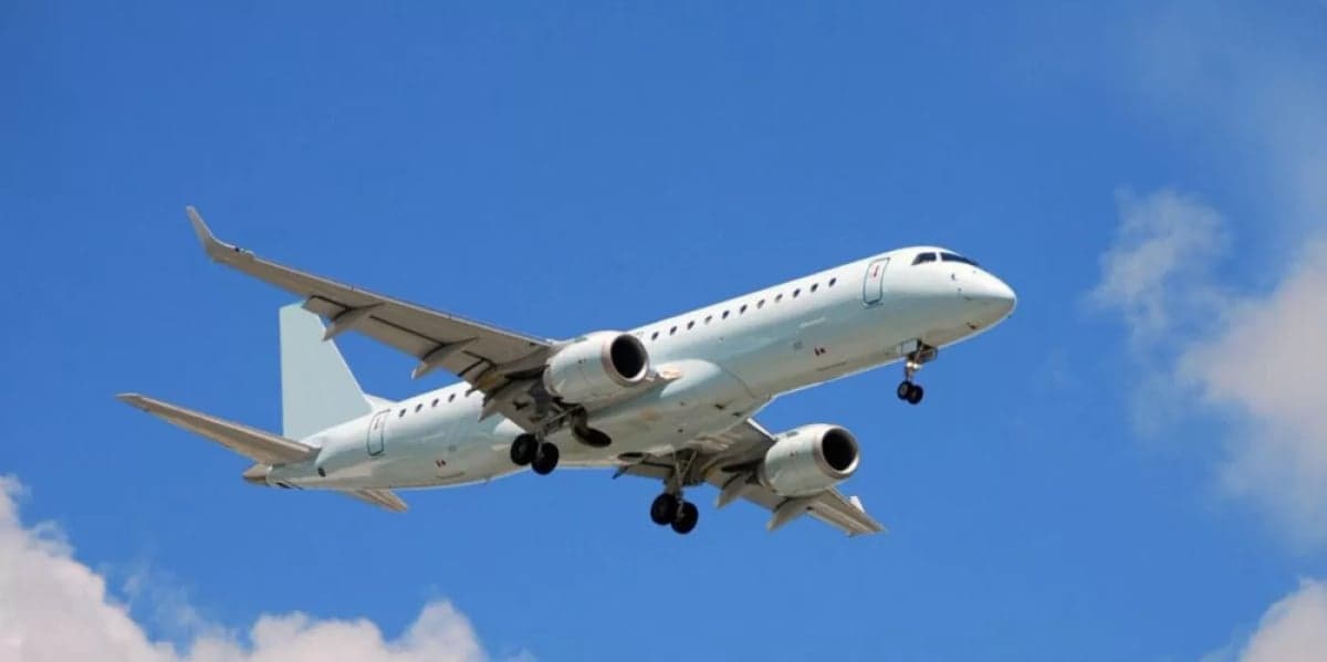 A generic regional jet is in flight against a blue sky.