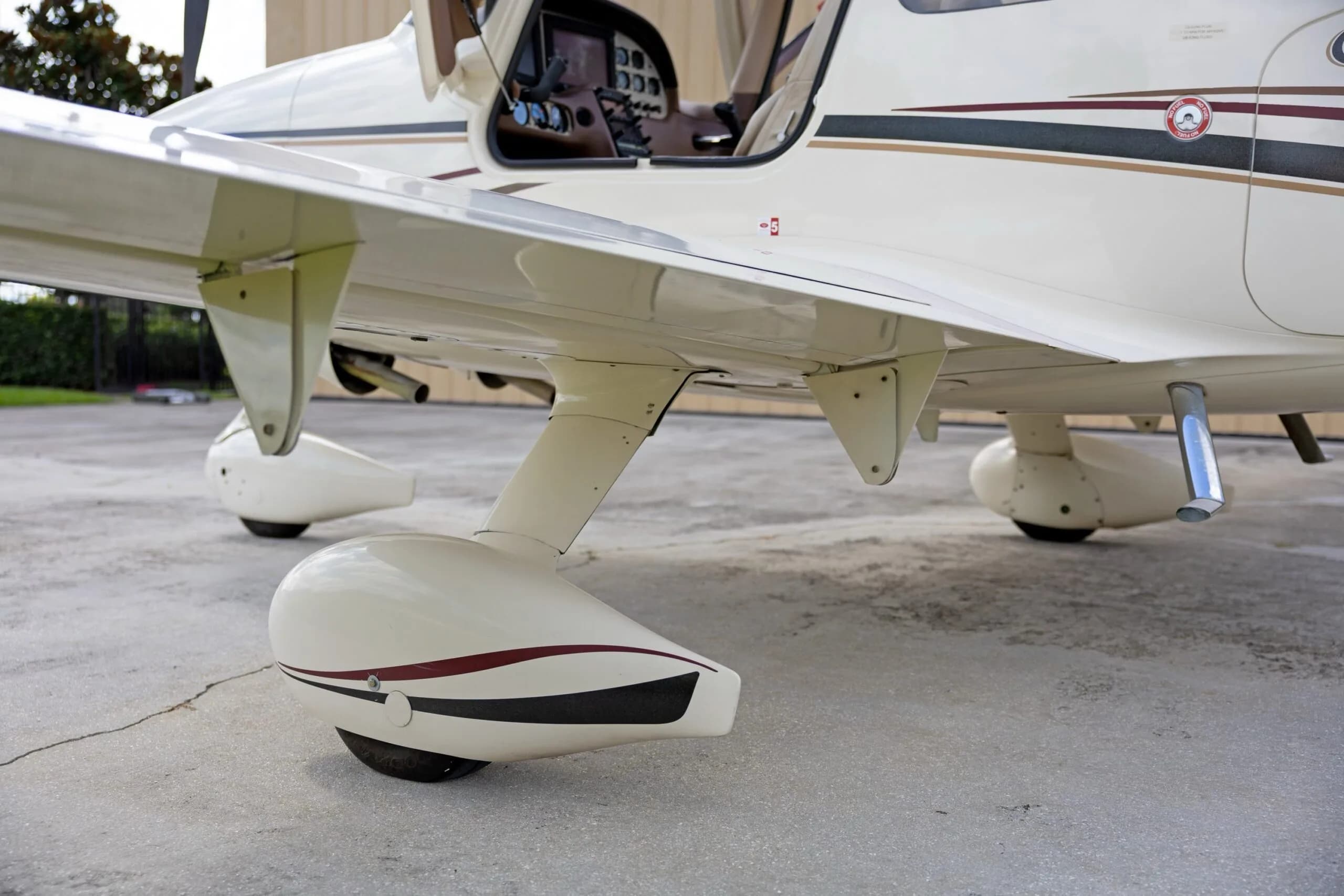 A close-up view of the main landing gear and wheel fairing of a white Cirrus SR22 aircraft.