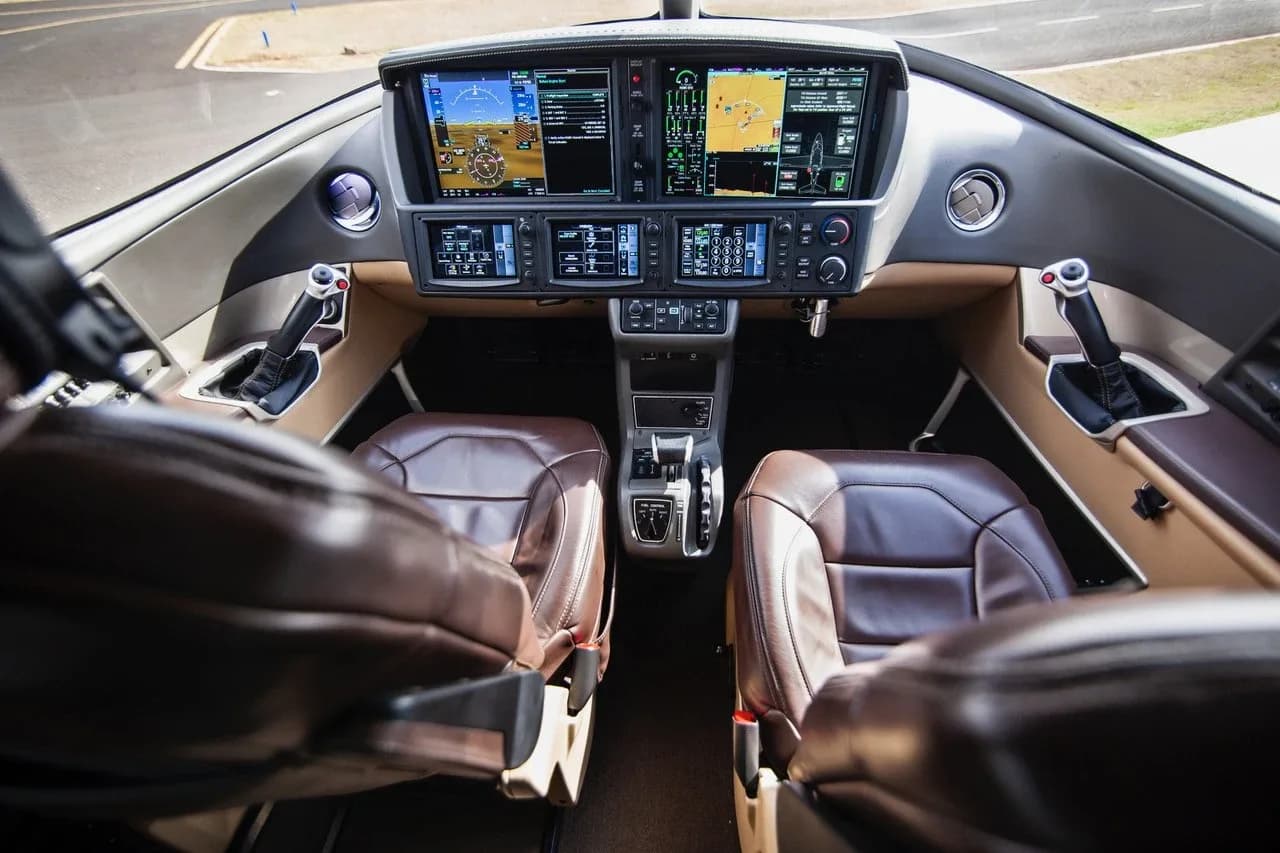 The modern glass cockpit and controls of a Cirrus Vision Jet, viewed from the passenger cabin.