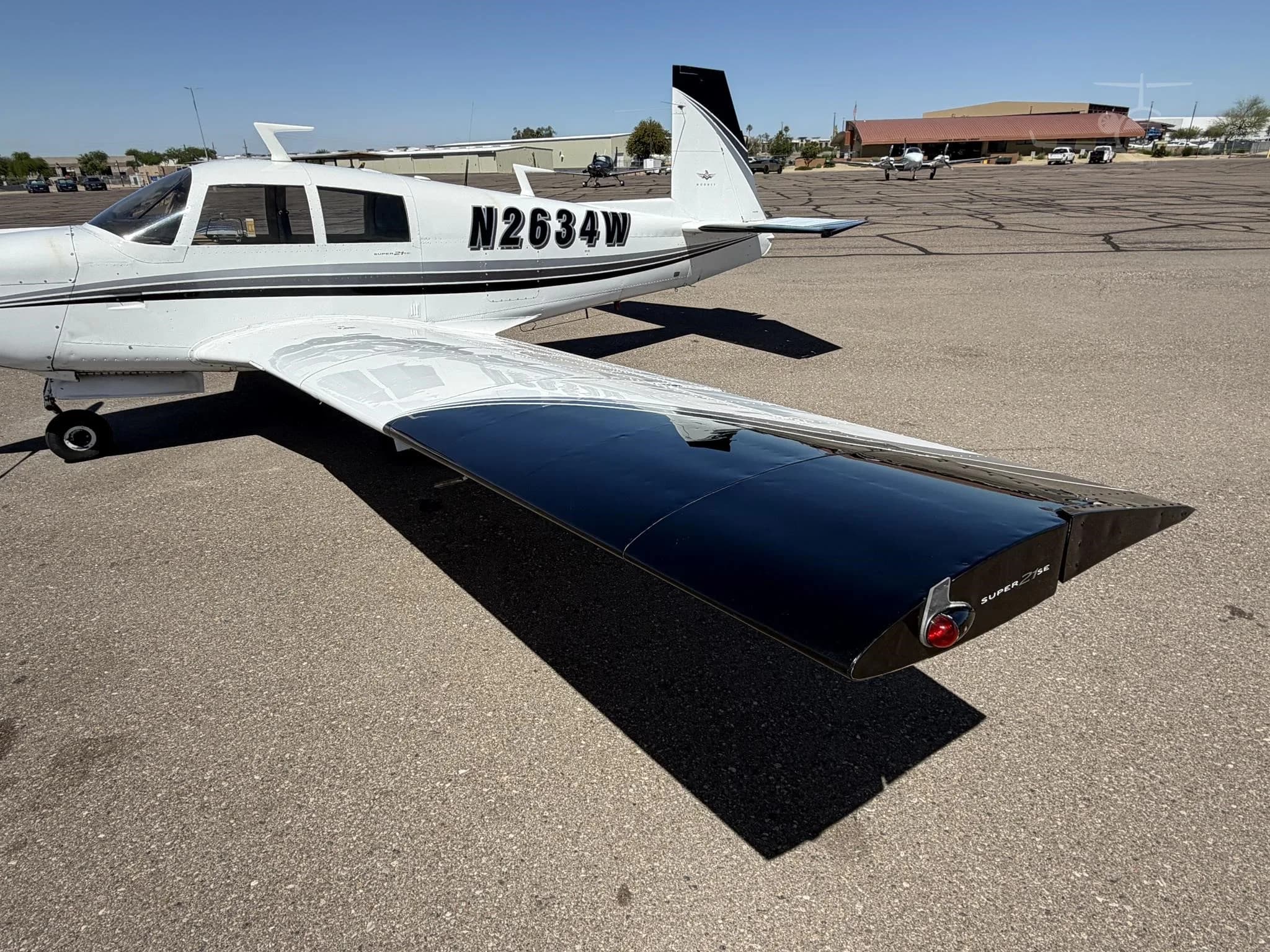 Rear view of the Mooney M20J Super 21SE aircraft showing the tail and registration number.
