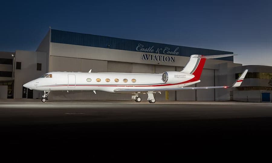 Gulfstream G550 parked in front of an aviation hangar.